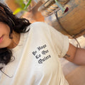 Front view of a cream-colored unisex crewneck  t-shirt featuring a design on the top left corner in black reading "yo hago lo que quiero"